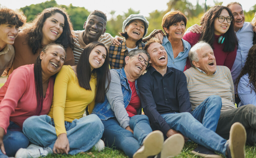 Group of multigenerational people having fun together outdoor - Multiracial friends enjoy day at city park